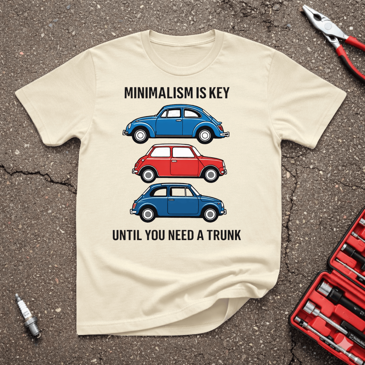 Minimalism Is Key funny automotive T-shirt with three small classic cars and text Until You Need A Trunk on Sand shirt.