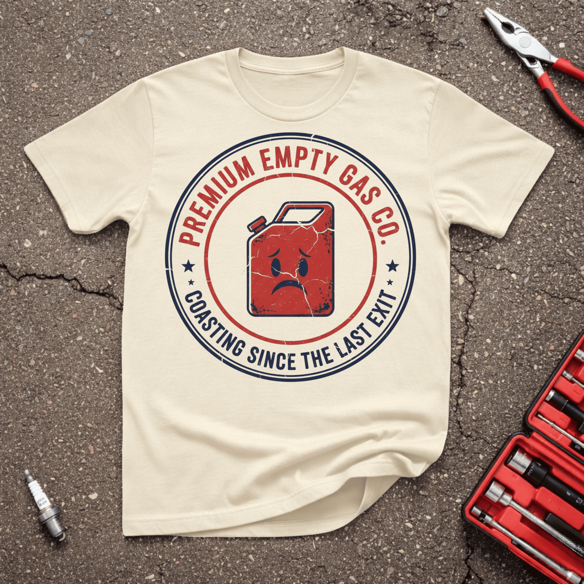 Coasting funny automotive T-shirt with distressed red empty gas can and Premium Empty Gas Co. Coasting Since The Last Exit badge on Sand shirt.