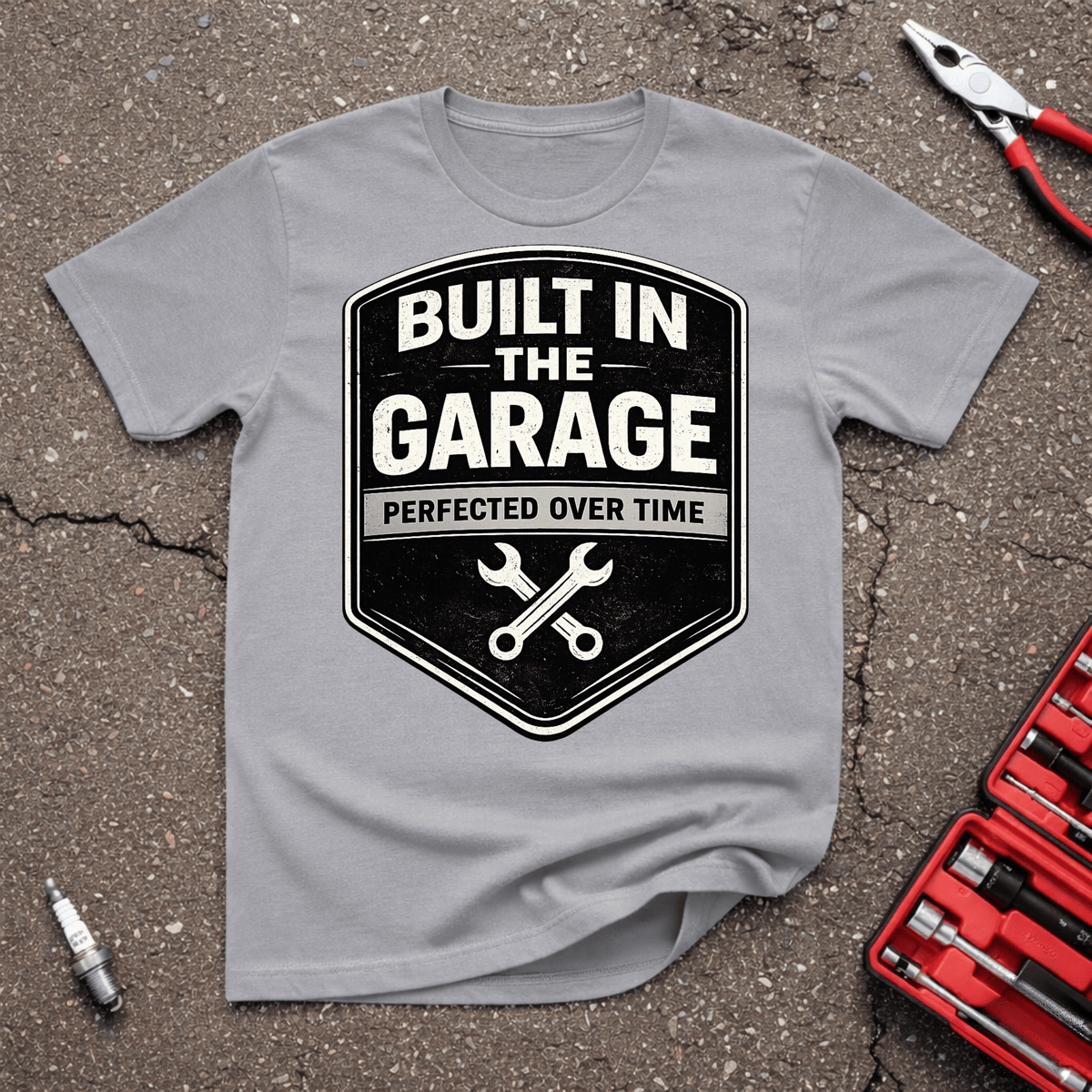 Perfected Over Time automotive T-shirt with black shield badge, crossed wrenches, Built In The Garage and Perfected Over Time text on Sport Grey shirt.